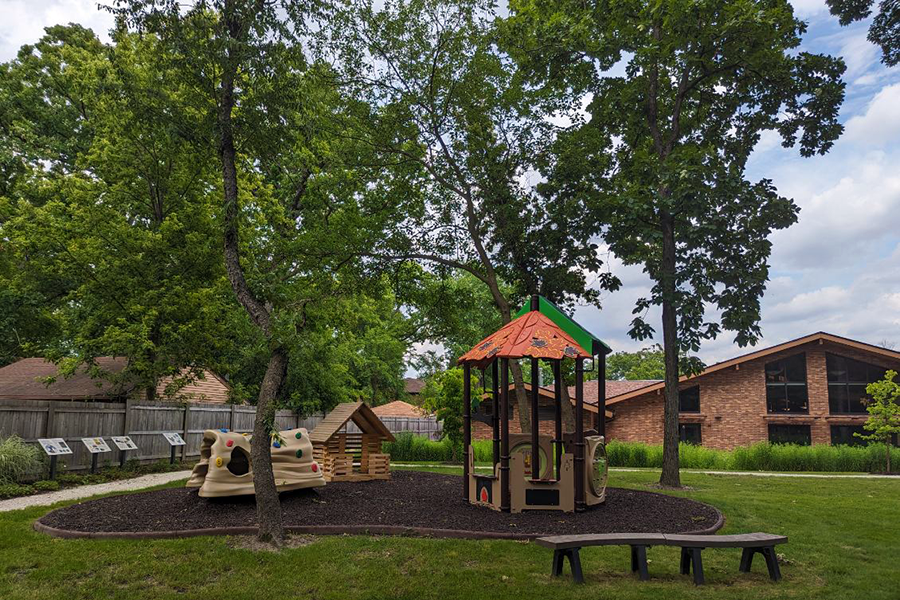 Outdoor play area with small playground and sitting area