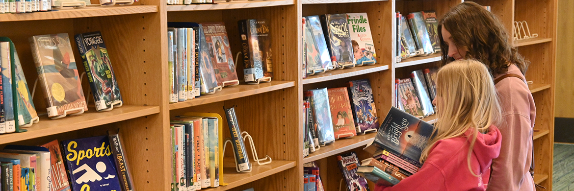 Mom and daughter browsing shelves at the library