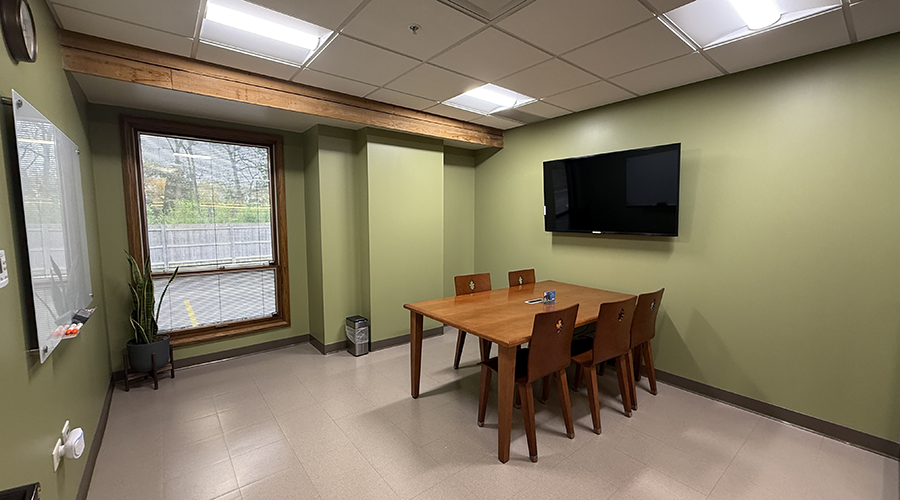 Study Room 1 interior with a table, four chairs, and a mounted monitor