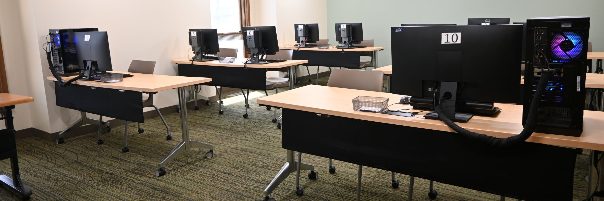 Computer lab with small workstations, each with one or two desktop computers