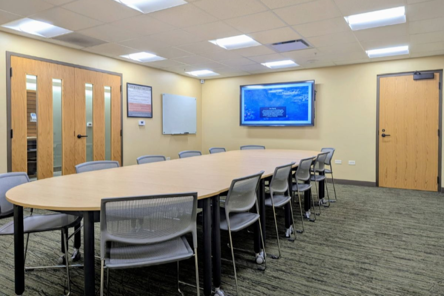 Small Meeting Room interior showing a conference table, chairs, and a mounted monitor