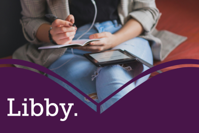 Libby resource image showing a woman with headphones in writing in a notebook with an open tablet on her lap
