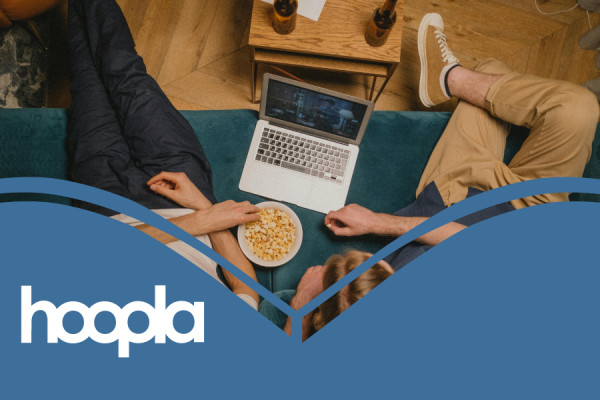 Hoopla movies graphic showing two people sitting on a couch with snacks and an open laptop