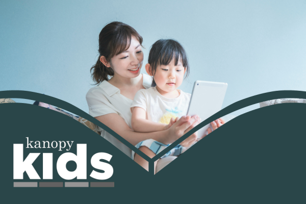 Kanopy for Kids resource image showing a mother holding her young daughter while watching something on a tablet