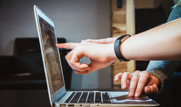Open laptop with someone pointing to the screen