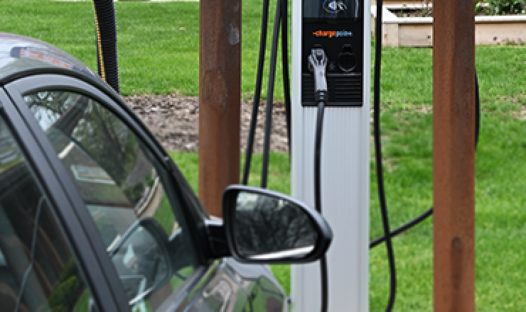 A photo of an electric vehicle being charged in front of the Library.