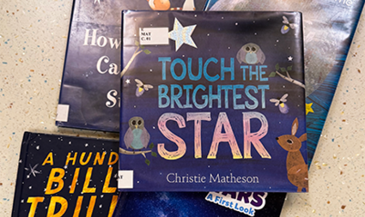 Several children's books in a pile together. They are all about stars and outer space.