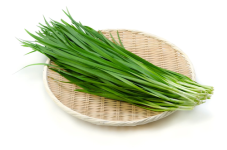 A clump of garlic chives resting on a woven mat.